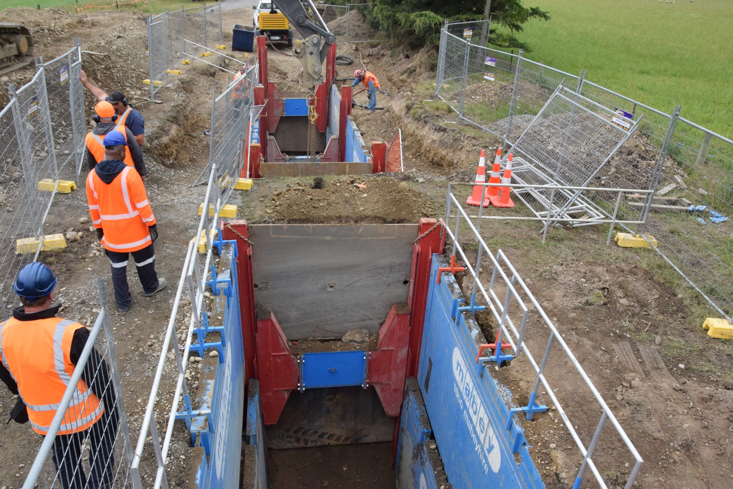 Crew overseeing excavation works with Mabey trench shields for safety